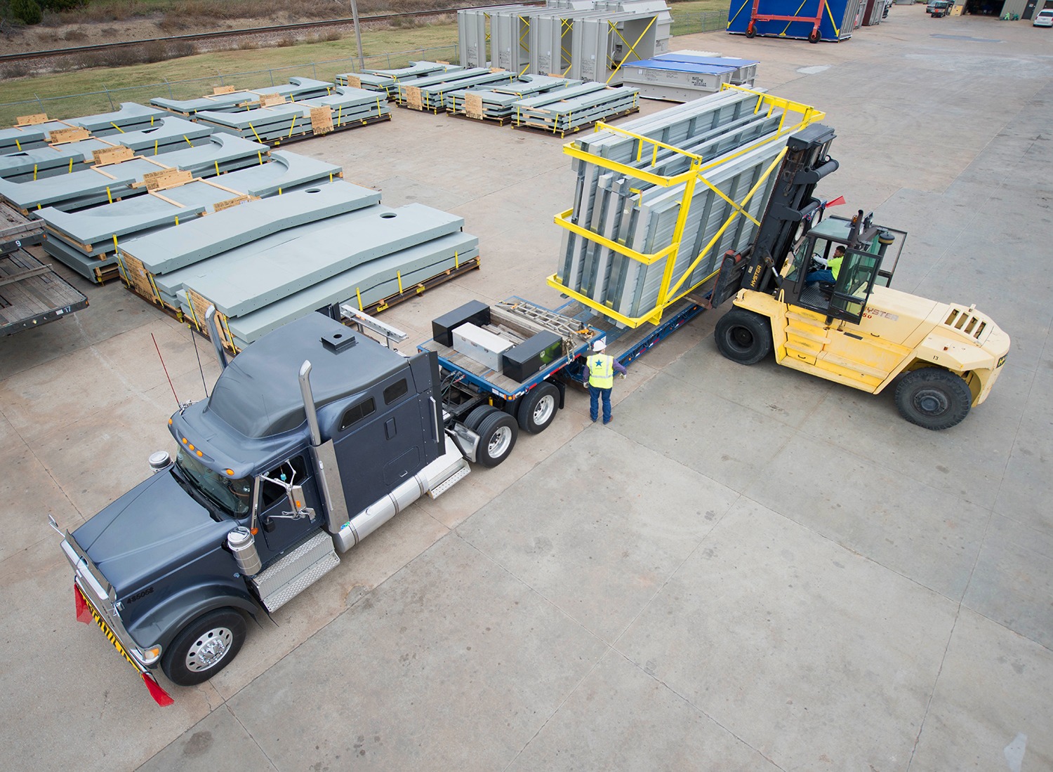 Landstar heavy-haul trailer being loaded with large industrial freight